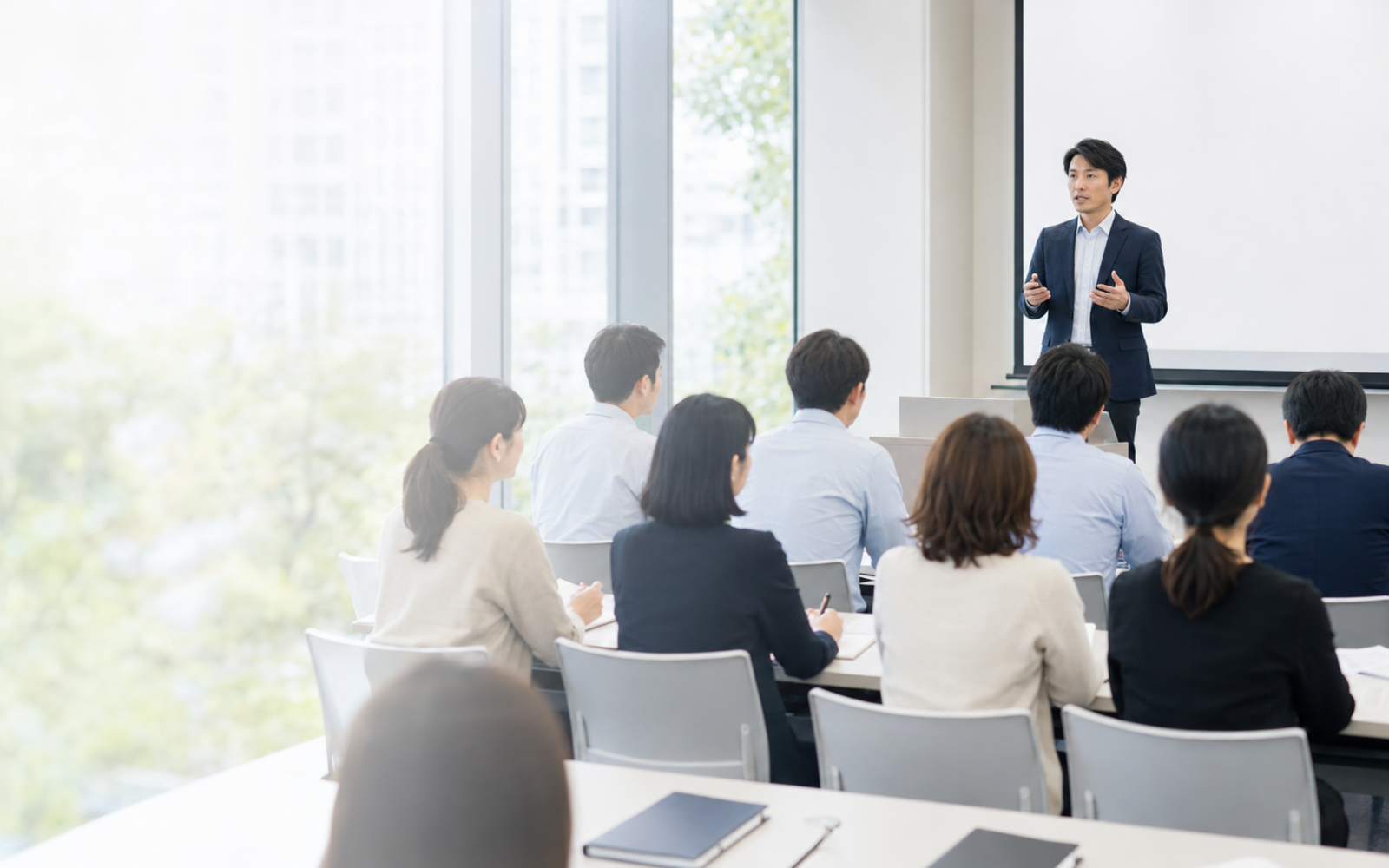 明るい教室で講義を受ける受講者のイメージ